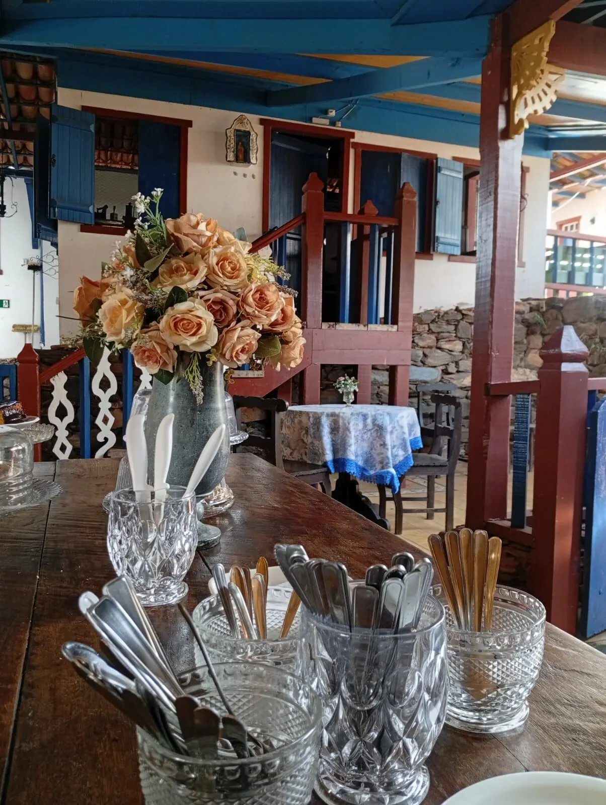 Mesa posta com flores e talheres em cristal