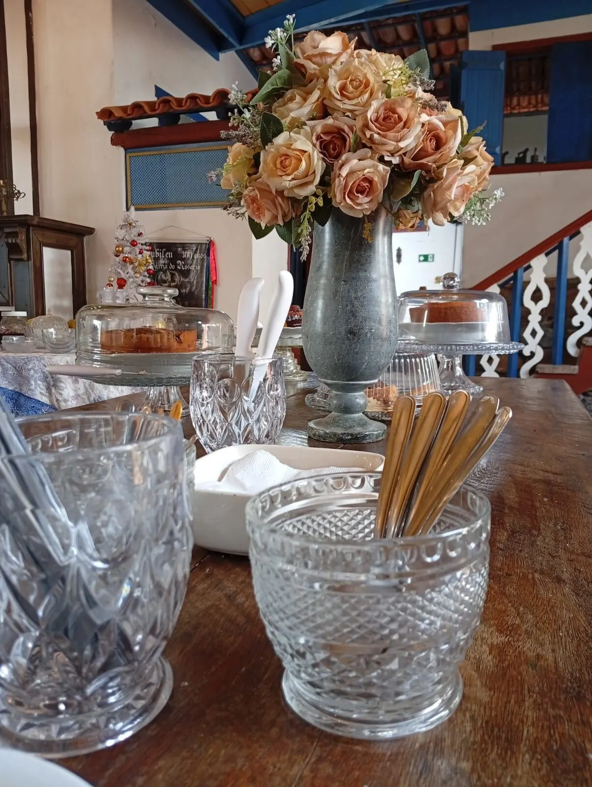 Vaso de rosas e cristais sobre mesa rústica