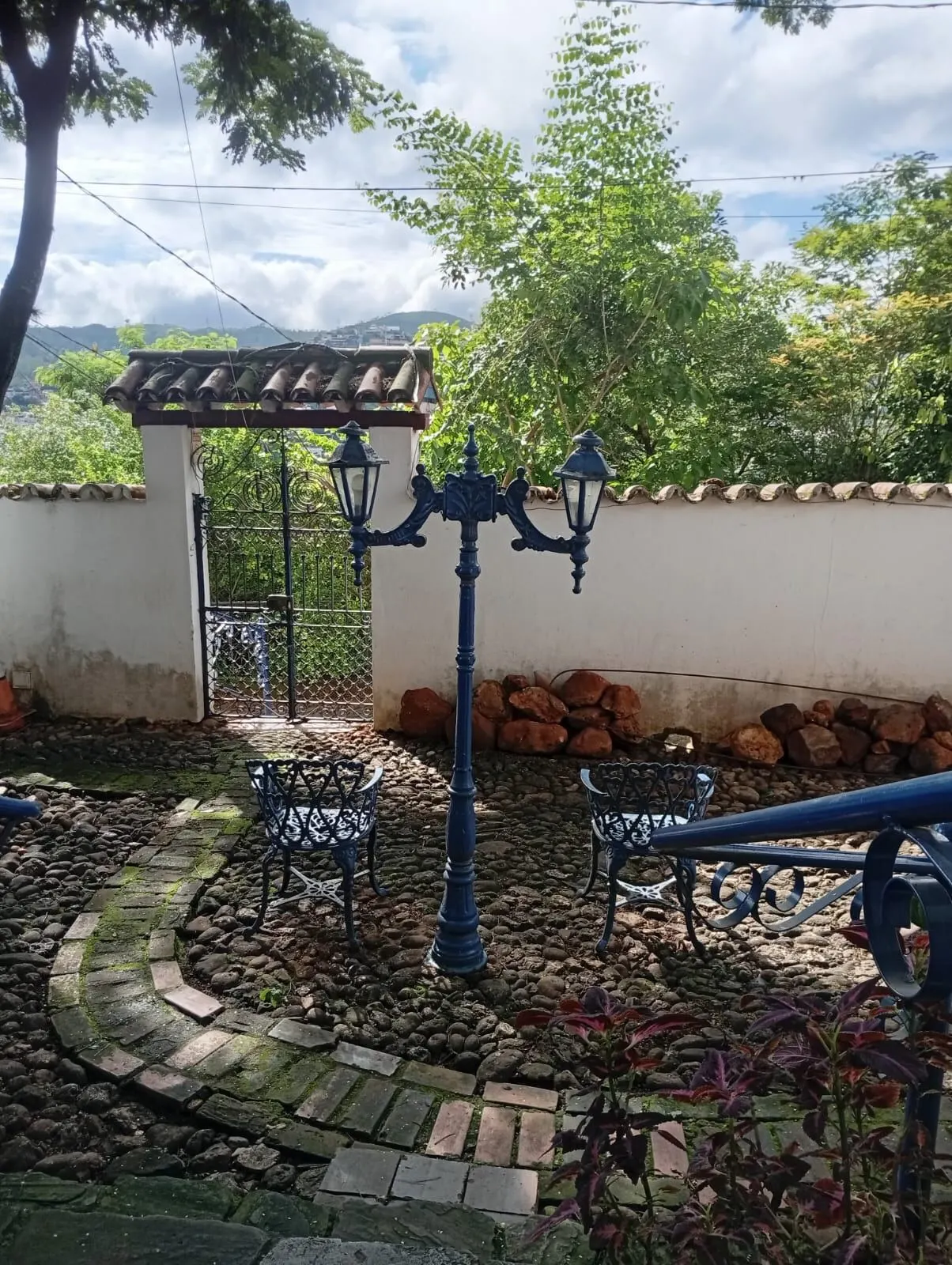 Portão e jardim com luminárias coloniais