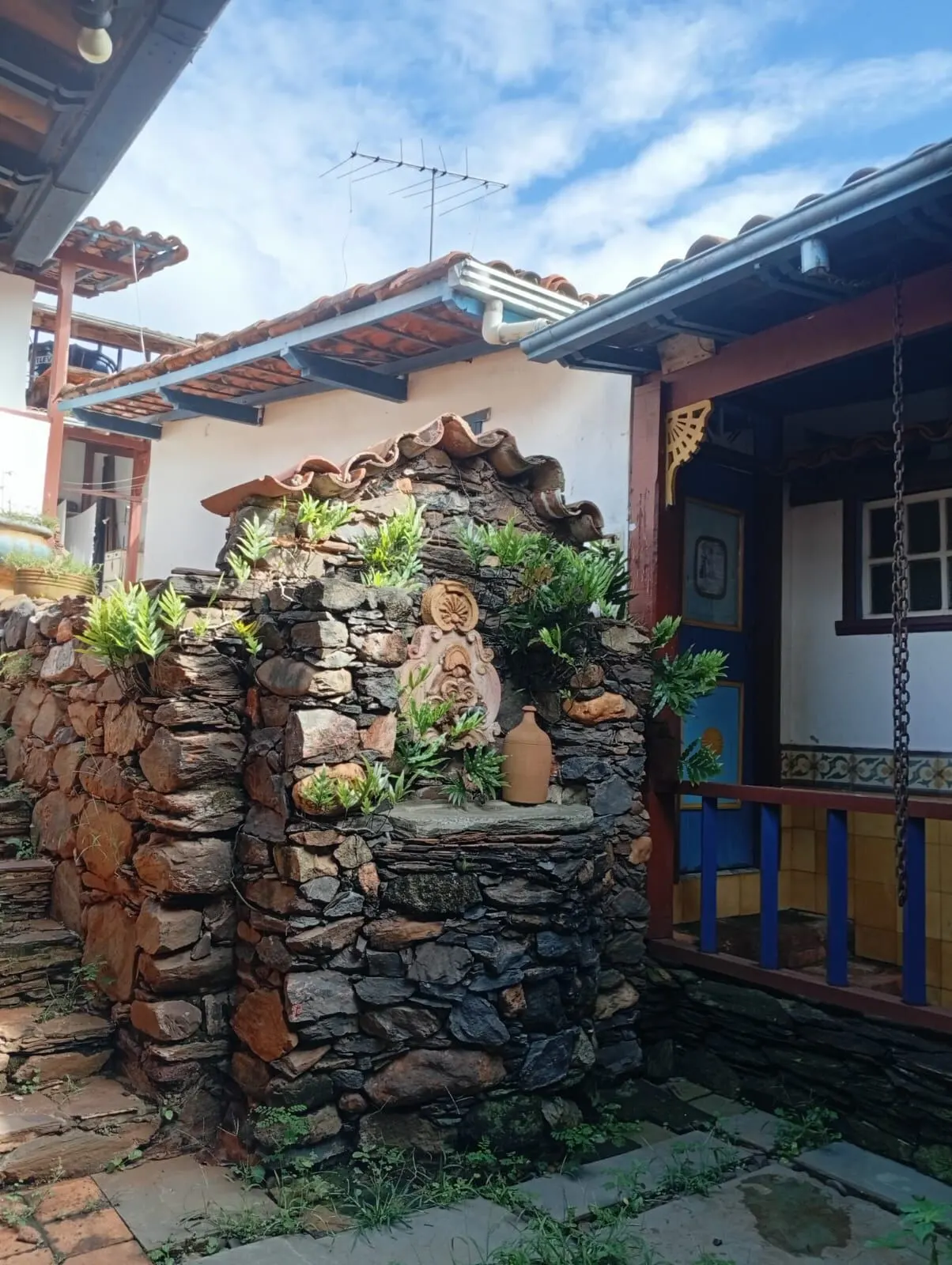 Fonte de pedra com plantas e samambaias