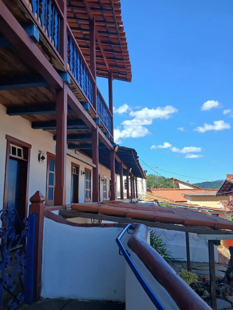 Varanda com balcões em madeira e telhado colonial