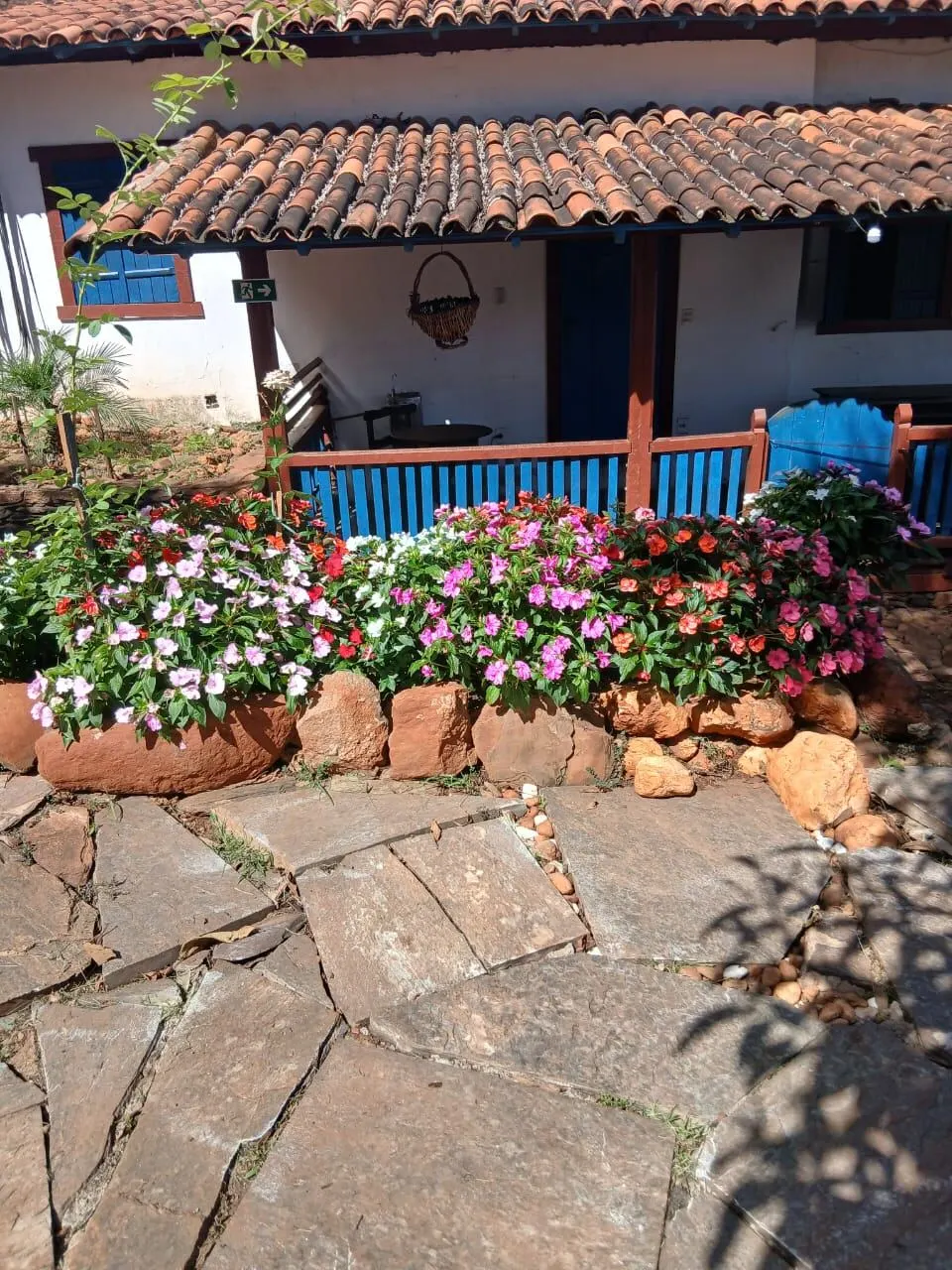 Varanda com flores penduradas e telhado de telhas