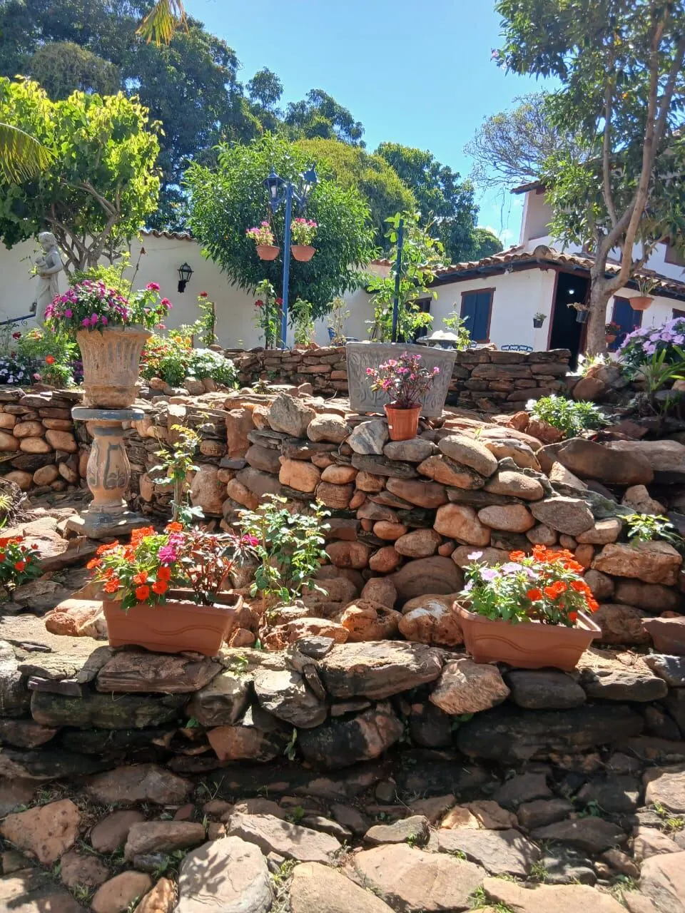 Jardim em pedra com flores e estátua